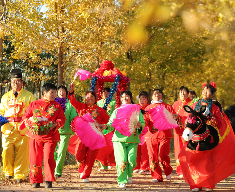 坎北街道肖港村業(yè)余藝術(shù)團在果林村銀杏網(wǎng)紅路表演歌舞節(jié)目